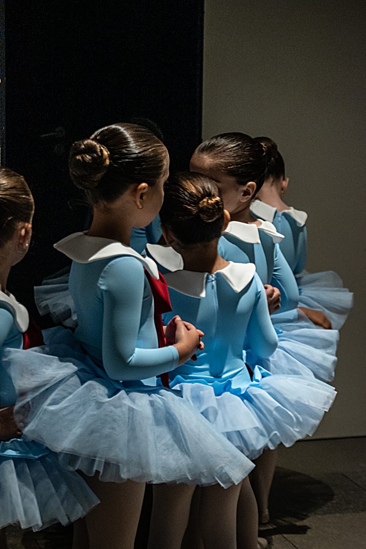Alumnes de ballet infantil amb tutús blaus i colls blancs, esperant backstage abans de sortir a l'escenari del festival
