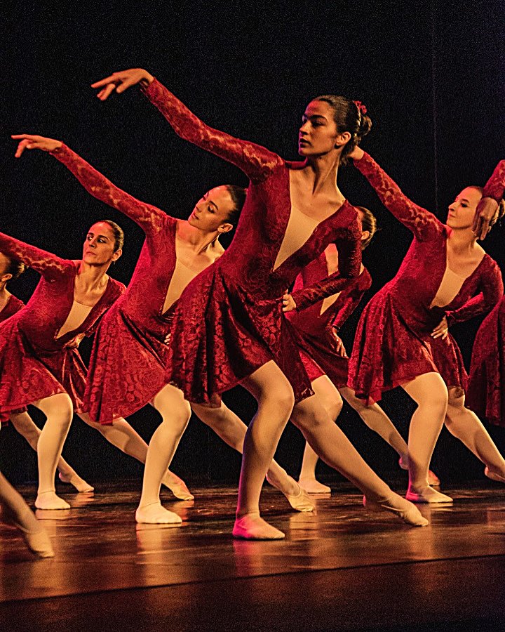 Grup d'alumnes de ballet amb vestits vermells de dansa en una pose del festival de fi de curs