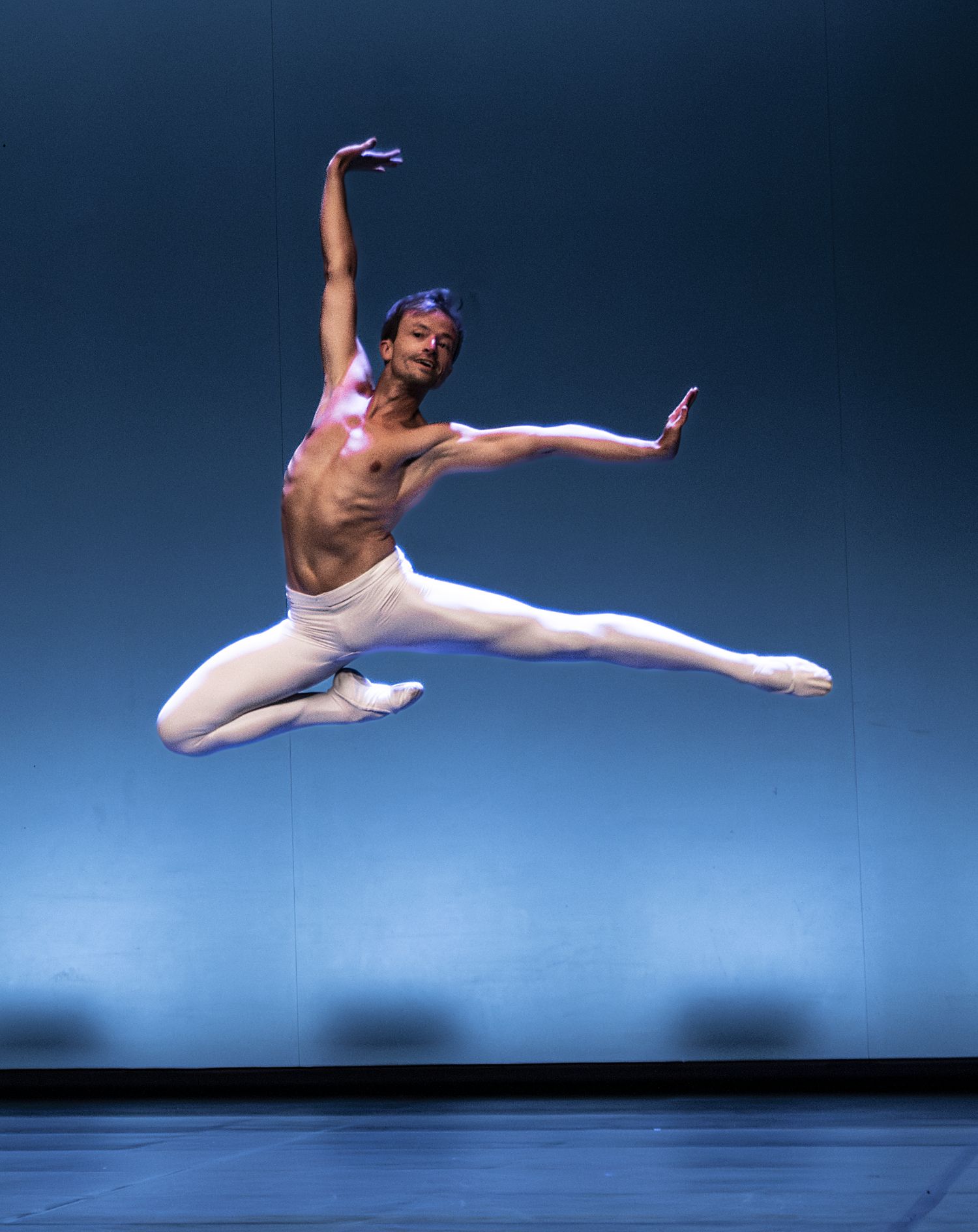 Guillem Bover en gran jeté a l'escenari del festival, amb llum blava