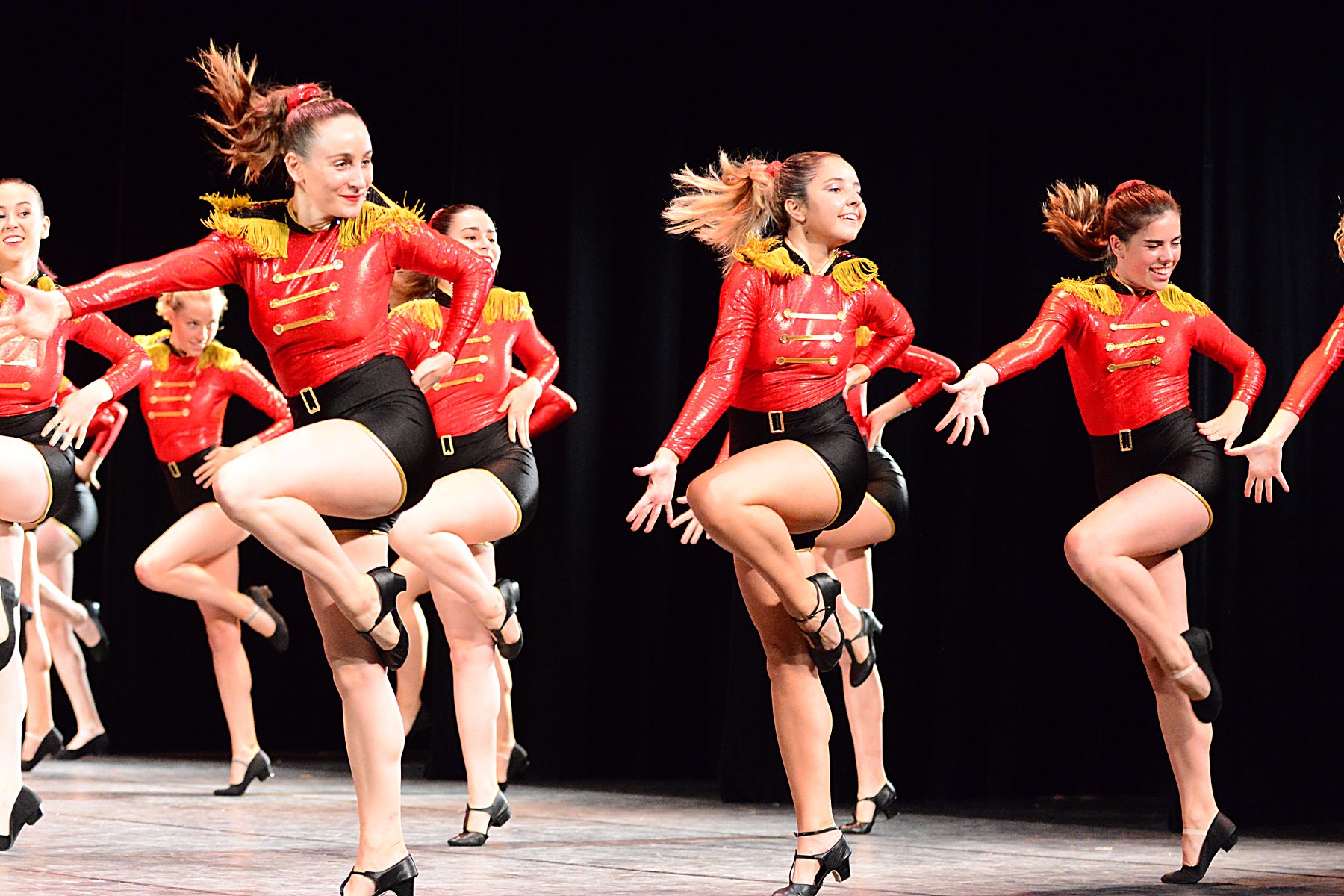 Grup de jazz de l'escola ballant amb jerseis vermells i detalls daurats al Teatre Municipal de Girona