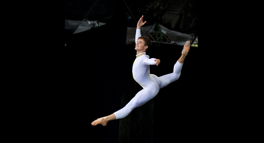 A dancer in mid grand jeté on stage